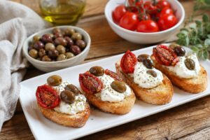 Bruschette con pomodori confit, stracciatella e olive in friggitrice ad aria